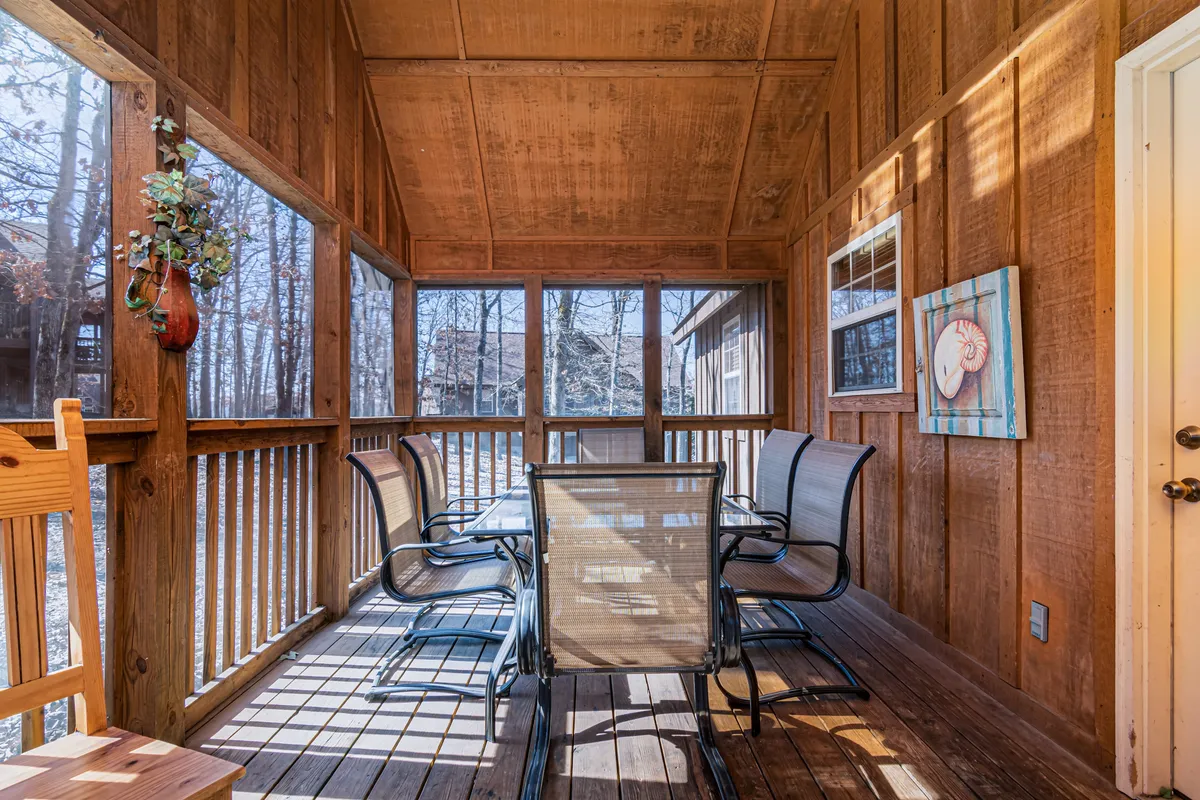 The image showcases a warm, inviting dining area with a stylish table and chairs, tasteful wall art, and large windows framing nature views. The space is designed for guests to gather, dine, and relax while soaking in the serene atmosphere of the lodge.